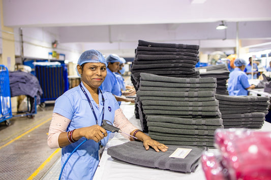 Workers in a laundry facility sort and organize towels.