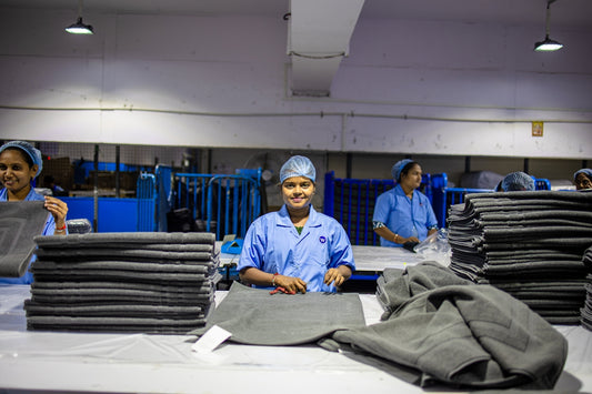 Workers are folding towels in a factory.