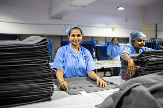 Workers fold clothing in a factory.
