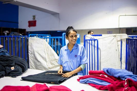 Laundry worker neatly folds clothes in a facility.